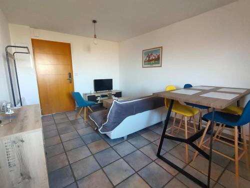 Zimmer mit einem Tisch, Stühlen und einem Schreibtisch in der Unterkunft T3 au pied des Pyrénées in Pointis-de-Rivière