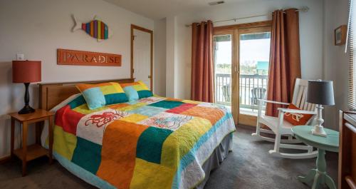 a bedroom with a colorful bed and a window at KH5007- Fore Sea Suns in Kitty Hawk