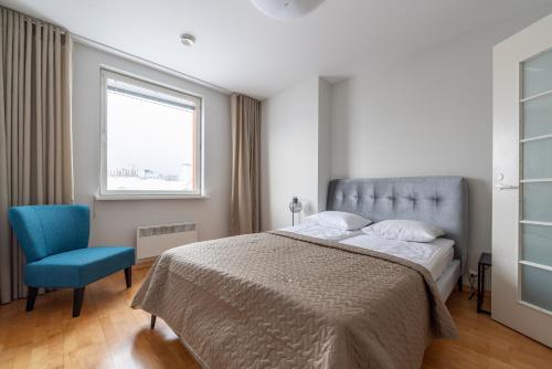 a bedroom with a bed and a blue chair at Old Town - Passaaz Apartment in Tallinn