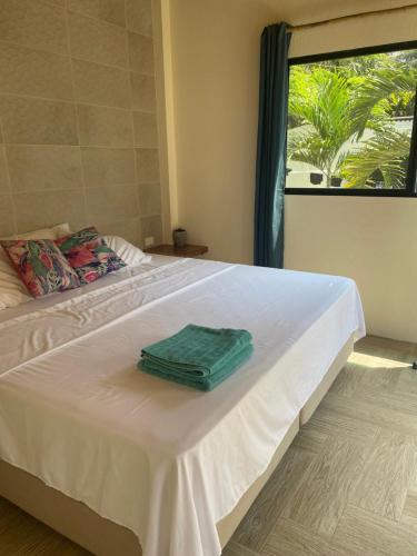 a white bed with a green box on top of it at Casa del Sol in Montañita