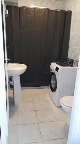 une salle de bain avec une machine à laver et un lavabo dans l'établissement Appartement proche croisette avec parking et climatisation, à Cannes
