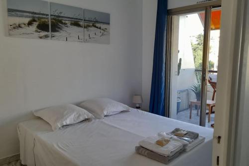 une chambre avec un lit blanc avec des serviettes dessus dans l'établissement Appartement proche croisette avec parking et climatisation, à Cannes