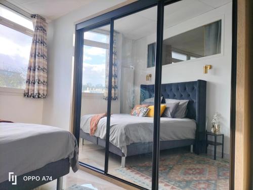 une chambre avec un lit et un grand miroir dans l'établissement IMHOST - Spacious Appt near PARIS, à Pantin
