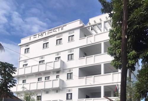 a white building with a sign on it at Le Majestic Toamasina Hotel in Toamasina