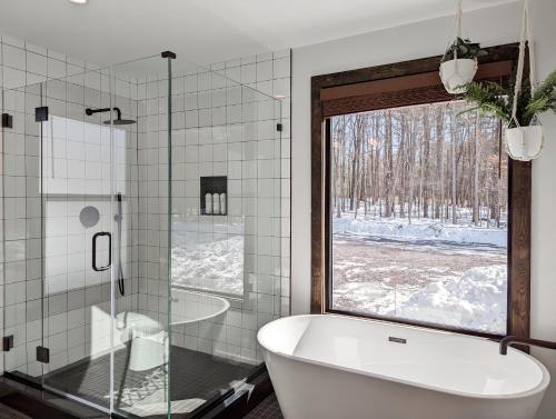 a bathroom with a tub and a large window at Acorn Bungalow - Luxury Cabin, Catskills, Windham Mountain, Hunter Mountain in Cairo