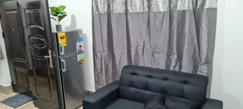 a living room with a couch and a refrigerator at NESTA BARRON -Home Away from Home in North Legon