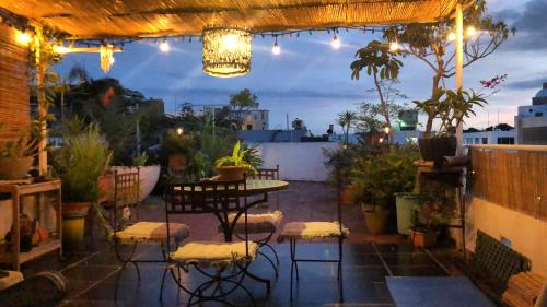a patio with a table and chairs and lights at Centrico ciudad colonial in Santo Domingo