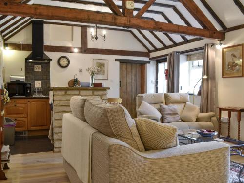 a living room with a couch and a fireplace at Bakery Cottage in Ampney Crucis