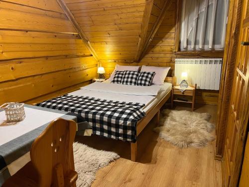 a bedroom with two beds in a wooden cabin at Na Poddaszu - apartament na wyłączność in Kluszkowce