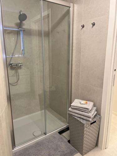 um chuveiro com uma porta de vidro e uma cesta com toalhas em Immobiliare Nk Palazzo Bonvicini em Veneza