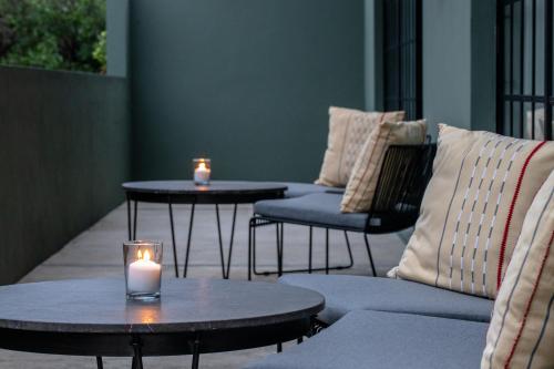 two candles are sitting on tables on a patio at Antelar Casa Destino in Mérida