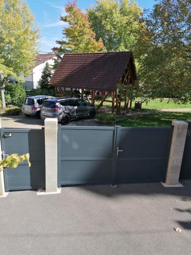 a fence in front of a building with a pavilion at Chambres d'hôtes chez Loulou et Caramel in Magstatt-le-Bas