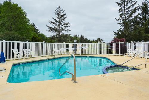 una piscina con sillas y una valla en Long Beach Camping Resort Studio Cabin 3, en Seaview