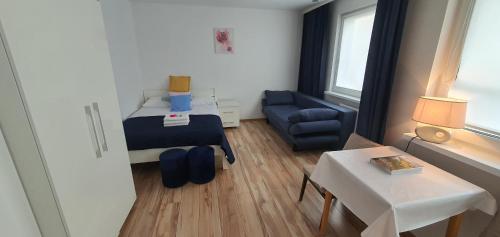 Cette petite chambre comprend un lit, une chaise et une table. dans l'établissement Apartament Altheide, à Polanica-Zdrój