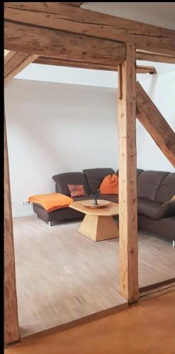 ein Wohnzimmer mit einem Sofa und einem Tisch in der Unterkunft Wohnen im Dreiseitenhof mit Galerieschlafzimmer in Neudietendorf