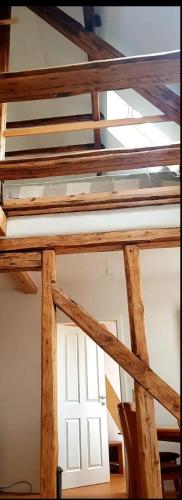 a white door in a room with wooden beams at Wohnen im Dreiseitenhof mit Galerieschlafzimmer in Neudietendorf