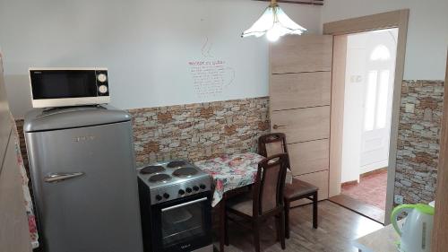 a kitchen with a stove and a table with a microwave at Divčibarski M.S.A. kutak in Divčibare