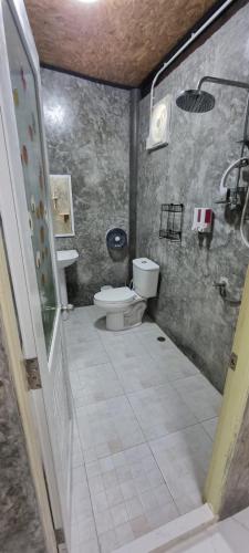 a bathroom with a toilet and a sink at Our Village Farmstay Kohmook in Ko Mook