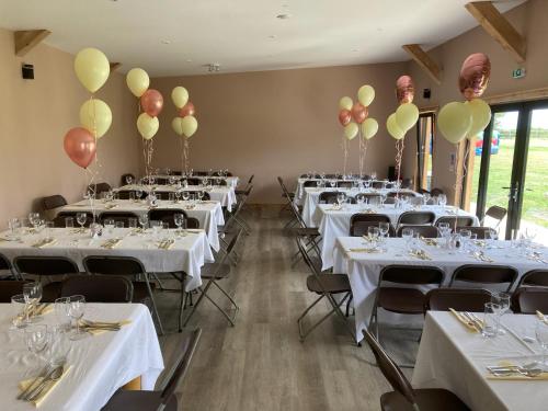 un salón de banquetes con mesas blancas y globos en las paredes en Knockreagh Farm Cottages, Callan, Kilkenny en Kilkenny