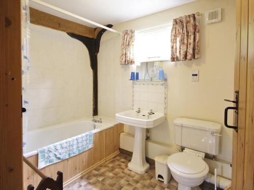 a bathroom with a tub and a toilet and a sink at The Granary - E3669 in Saxtead