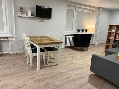 a living room with a wooden table and chairs at Saulėti apartamentai Trakuose/Sunny apartment in Trakai in Trakai