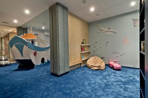 um quarto para crianças com uma área recreativa com escorrega em Apartament Zatoka 19 em Puck