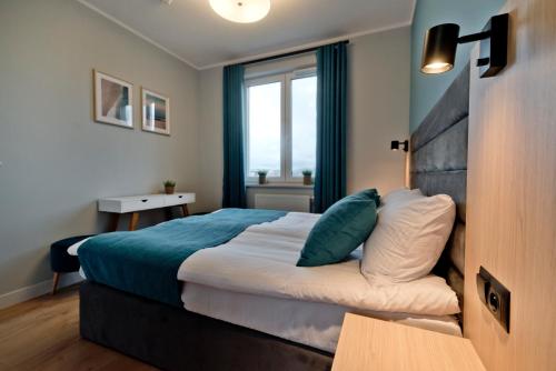 um quarto com uma cama grande e uma janela em Apartament Zatoka 19 em Puck