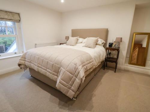 a bedroom with a large bed with white sheets and a window at Castle House in Rhyl