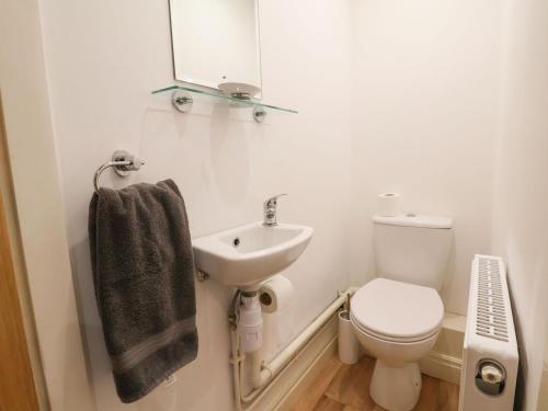 a bathroom with a sink and a toilet and a mirror at Castle House in Rhyl