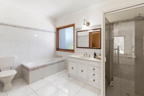 a bathroom with a tub and a sink and a toilet at Creating Memories on Wyndham - sleeps 16! in Drysdale