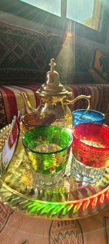 a glass tray with different colored bowls on a table at Traditional place with a Special Moroccan touch I Fibre Internet Up to 100 Mbps I PALMS Residence in Er Rachidia
