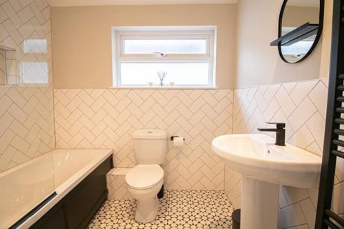 a bathroom with a toilet and a sink and a window at Burnaby's home, by Home Host, free on street parking in Cardiff
