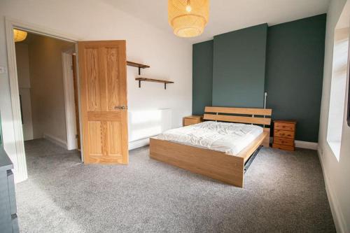 a bedroom with a bed and a wooden door at Burnaby's home, by Home Host, free on street parking in Cardiff