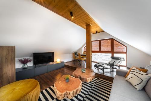 a living room with a couch and a table at Cozy mountain attic apartment in High Tatras in Veľká Lomnica