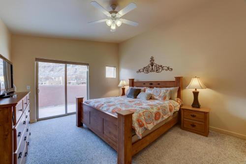 a bedroom with a bed with a ceiling fan and a window at Prickly Pear Vista in Moab