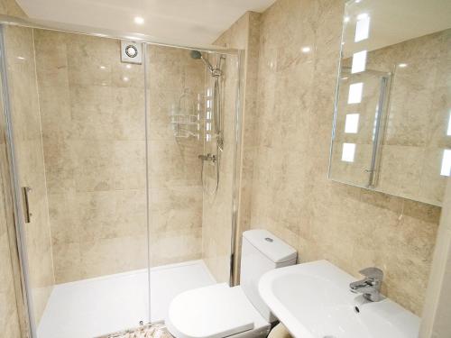 a bathroom with a shower and a toilet and a sink at River Cottage - E5462 in Wainfleet All Saints