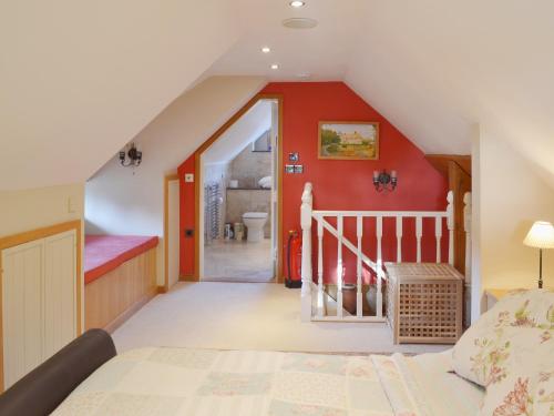 a attic bedroom with a bed and a staircase at Brixton Barn in Mottistone