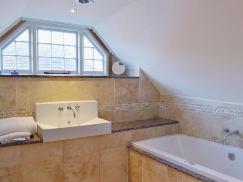 a bathroom with a sink and a bath tub at Brixton Barn in Mottistone
