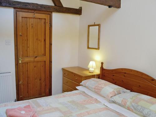 a bedroom with a wooden bed and a wooden door at Pinewood - E3077 in Thorpe Market