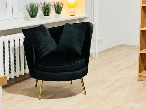 a black leather chair sitting in a room at Saulėti apartamentai Trakuose/Sunny apartment in Trakai in Trakai