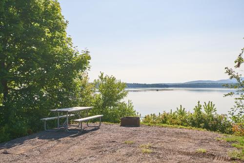 a picnic table sitting on the side of a lake at Narrows Too Camping Resort Cabin 6 in Trenton