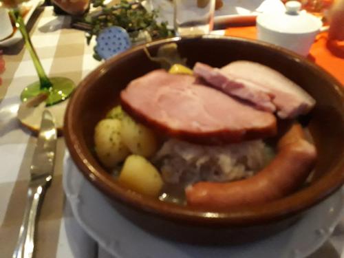 a bowl of food with meat and potatoes on a table at Chambres d'hôtes chez Loulou et Caramel in Magstatt-le-Bas