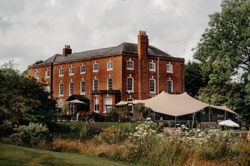 a large brick building with a tent in front of it at Verzon House in Ledbury