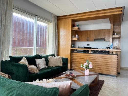 a living room with a green couch and a table at Anfa Sky Luxury Apart by SABOR VOYAGE in Casablanca