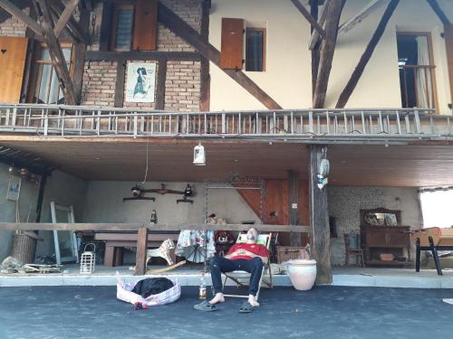 a woman is sitting on a table in a building at Chambres meublées chez Loulou et Caramel in Magstatt-le-Bas