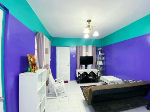 a living room with a purple and green wall at Kalai's Rental Dwellings (KRD) in Cotcot