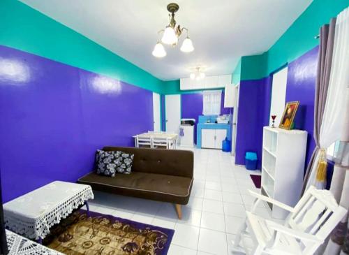 a living room with a couch and a purple wall at Kalai's Rental Dwellings (KRD) in Cotcot