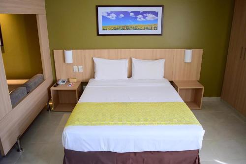 a bedroom with a large white bed in a room at Apto c piscina aquecida e Wi-Fi em Caldas Novas GO in Caldas Novas