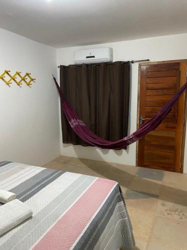 a bedroom with a bed and a window with a curtain at Jangadas do Pontal in Fortim
