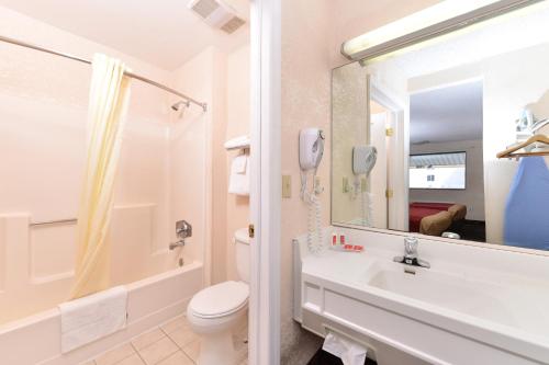 Bellmawr Economy Inn Bellmawr-Philadelphia Area في بيلماور: حمام مع حوض ومرحاض ومرآة
